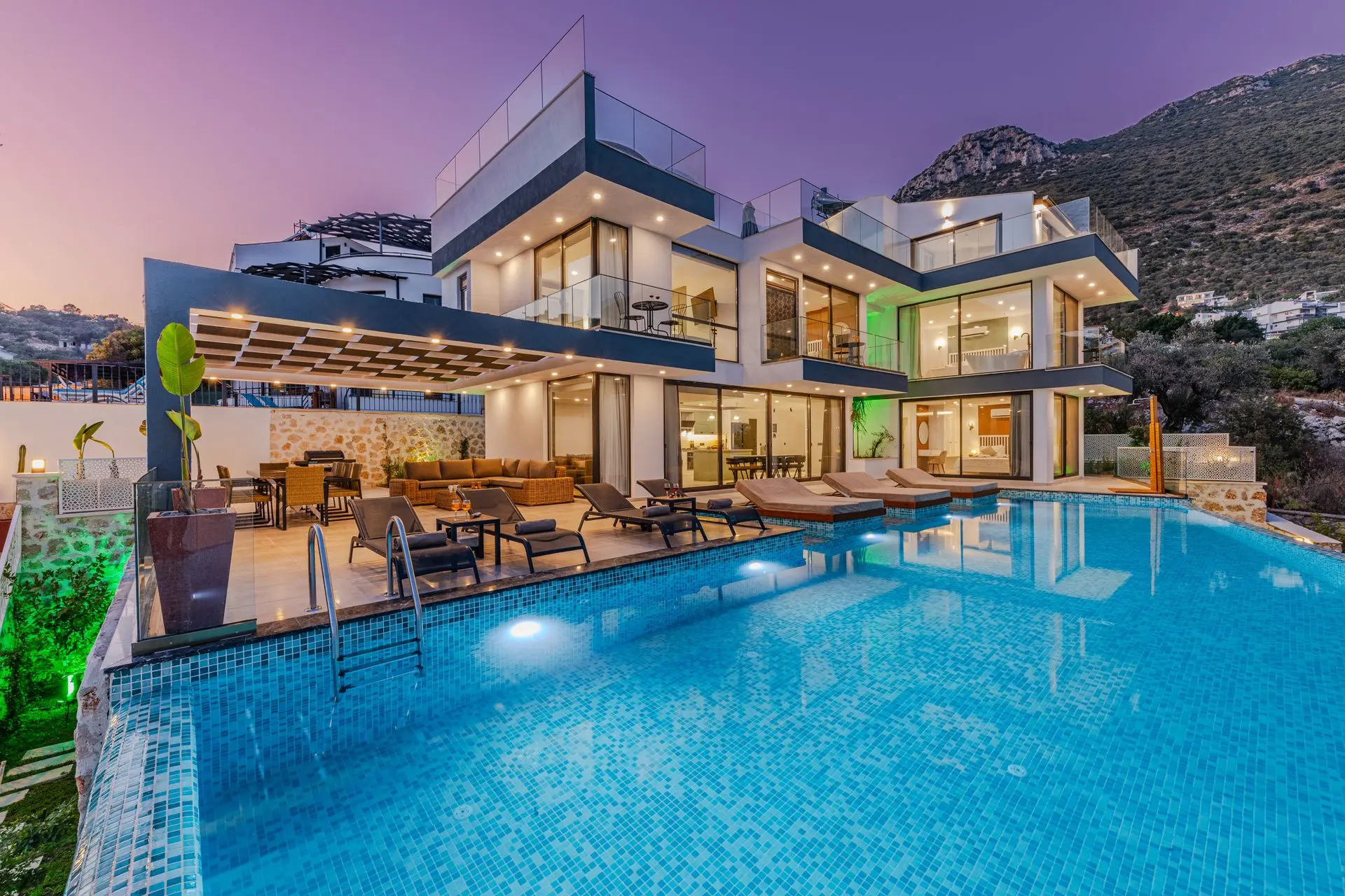 Alacakaranlıkta aydınlatılmış modern villa ve havuz